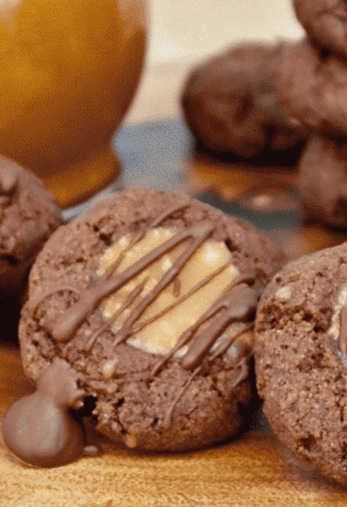 Close view of chocolate keto thumbprint cookies filled with caramel. 
