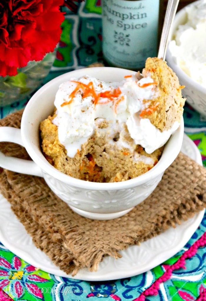 Low carb mug cake with whipped cream and shreds of carrots on top.