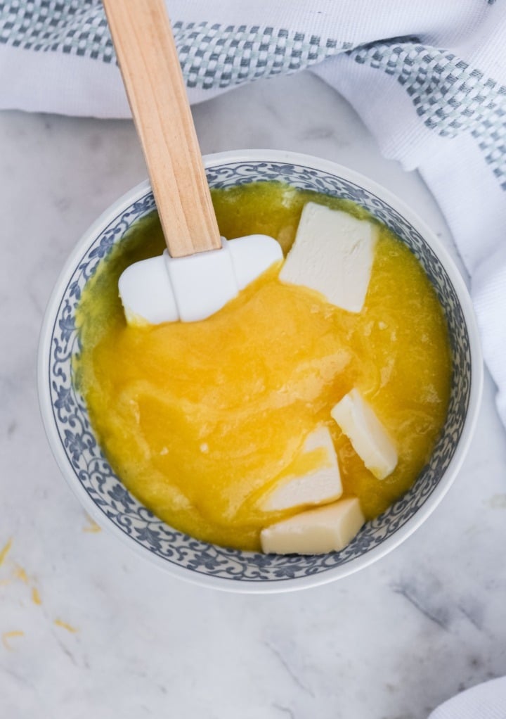 Adding butter to warm lemon curd. 