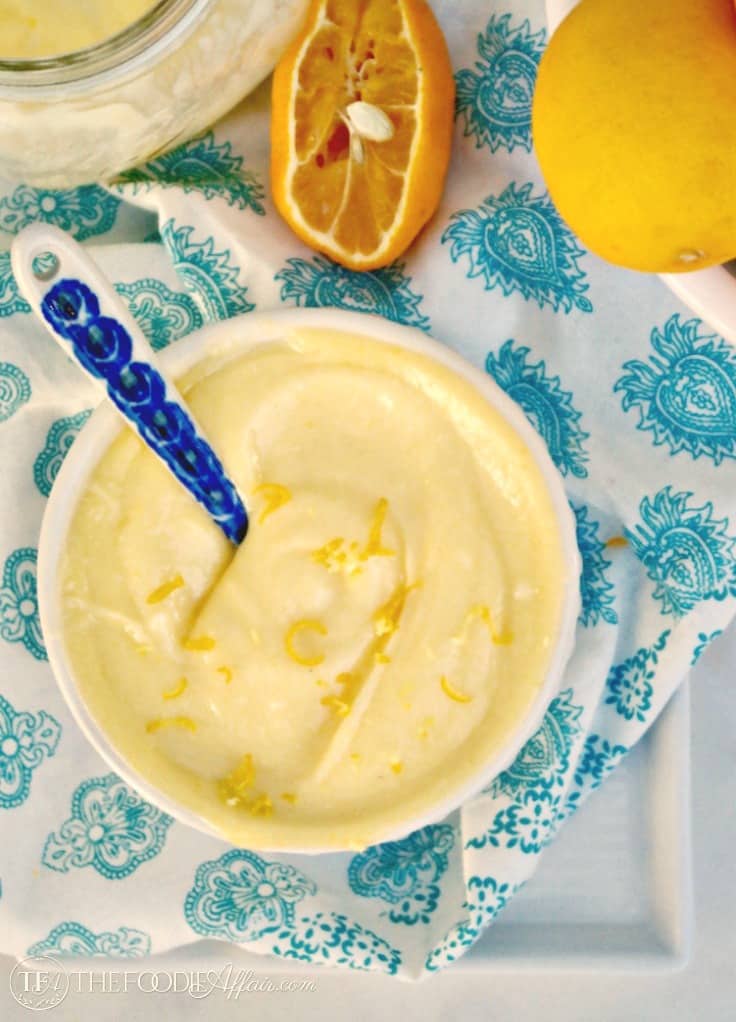Sugar free lemon curd with lemon zest in a white bowl over a teal colored napkin