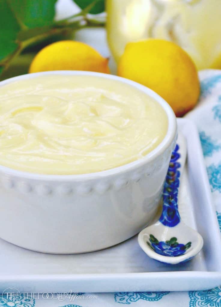 Low carb lemon curd in a white bowl with a blue flowered spoon