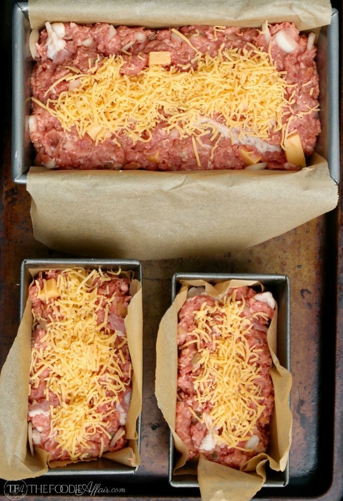 uncooked low carb meatloaf packed with chunks of cheese adding flavors just like a burger on a baking tray