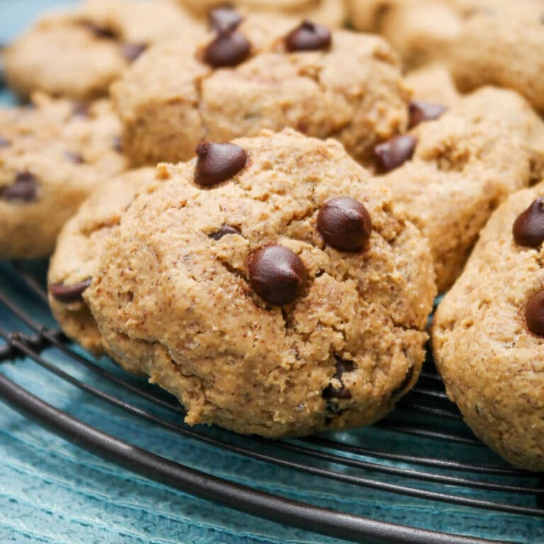 Almond butter cookies with chocolate chips on a baking cooking rack.