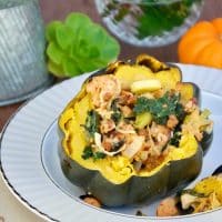 Kale with chicken sausage in baked squash on a gold rimmed plate