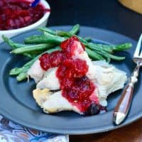 Healthy Cranberry Sauce without sugar topped on slices of turkey on a black plate with green beans #Healthy #CranberrySauce #LowCarb | www.thefoodieaffair.com