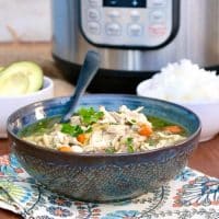 Teal patterned bowl of instant pot chicken soup on a flowered napkin #Chicken #Soup #Instant Pot | www.thefoodieaffair.com