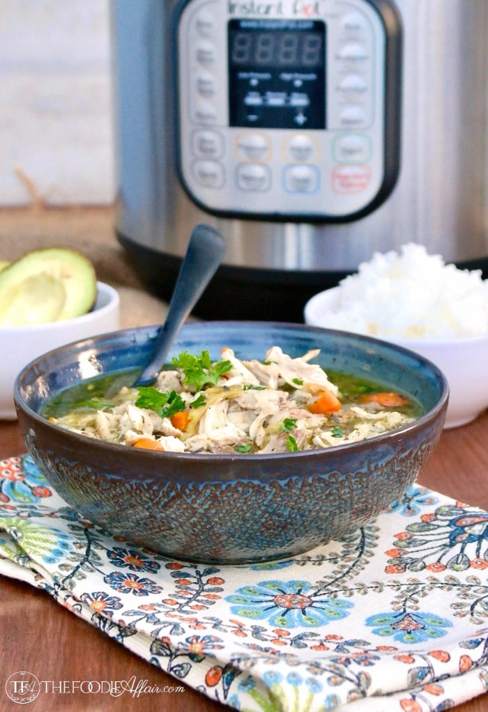 Teal patterned bowl of instant pot chicken soup on a flowered napkin #Chicken #Soup #Instant Pot | www.thefoodieaffair.com