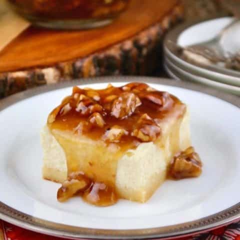 Creamy sugar free cheesecake bars with a maple pecan topping on a white plate with a silver rim #Cheesecake #SugarFree #LowCarb | www.thefoodieaffair.com