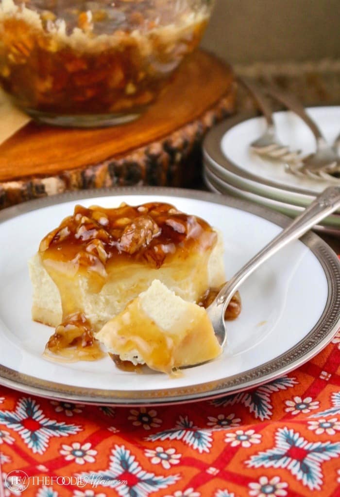 A fork cutting into sugar free cheesecake bars topped with a gooey maple pecan topping #Cheesecake #KetoDiet #Recipe #Glutenfree | www.thefoodieaffair.com