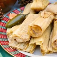 Homemade tamales in corn husk wraps on a plaid platter #tamales #homemade #recipe | www.thefoodieaffair.com