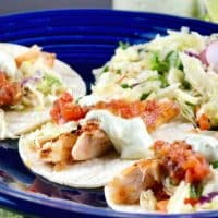 Healthy Fish Tacos recipe with fresh caught cod topped with salsa, avocado cream and slaw.