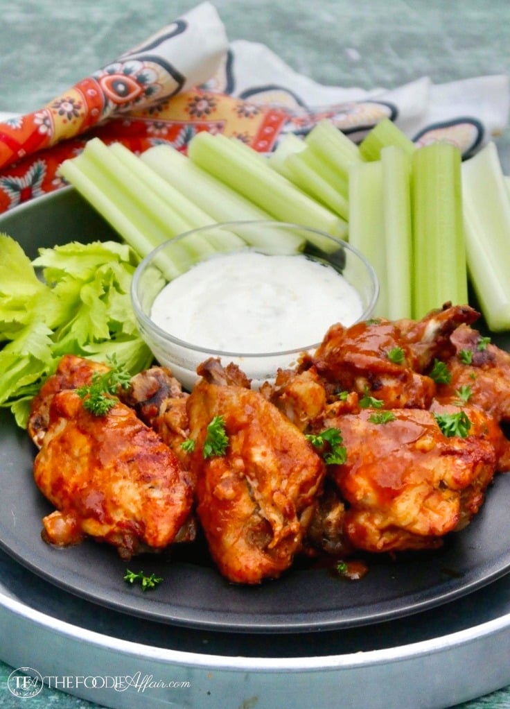 Instant Pot Chicken Wings on a black plate with celery and blue cheese dressing #instantpot #chickenwings #appetizer | www.thefoodieaffair.com