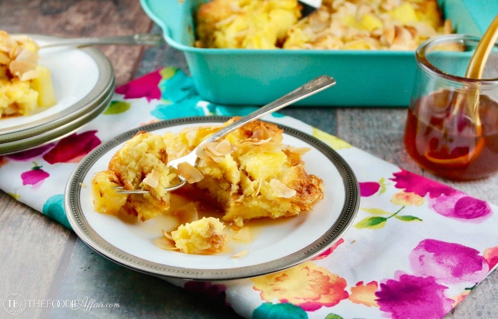 Pineapple bread pudding on a white plate with a bright pink and teal napkin