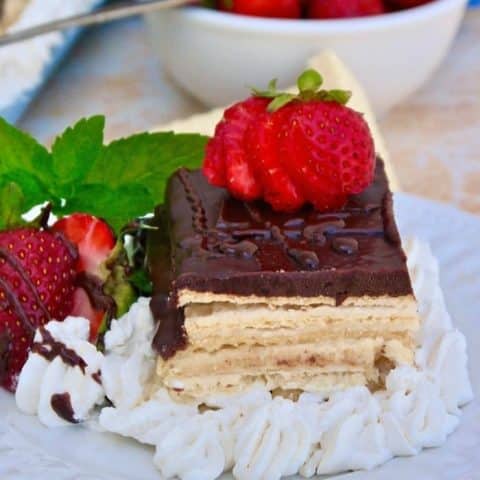Slice of eclair dessert with strawberries on a white plate