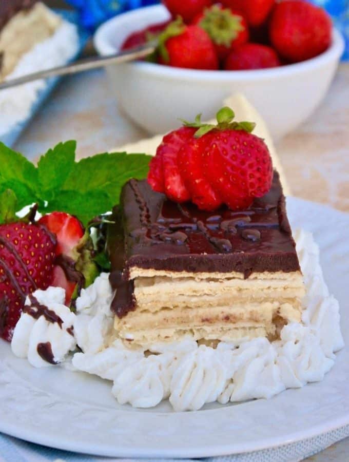 Slice of eclair dessert with strawberries on a white plate