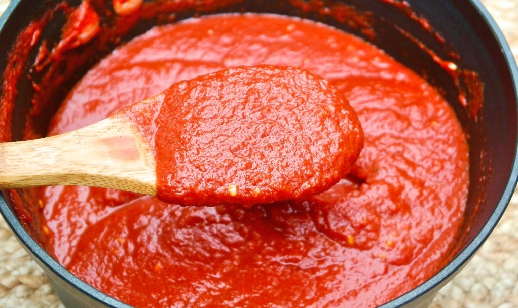 Marinara sauce simmering in a black pot.