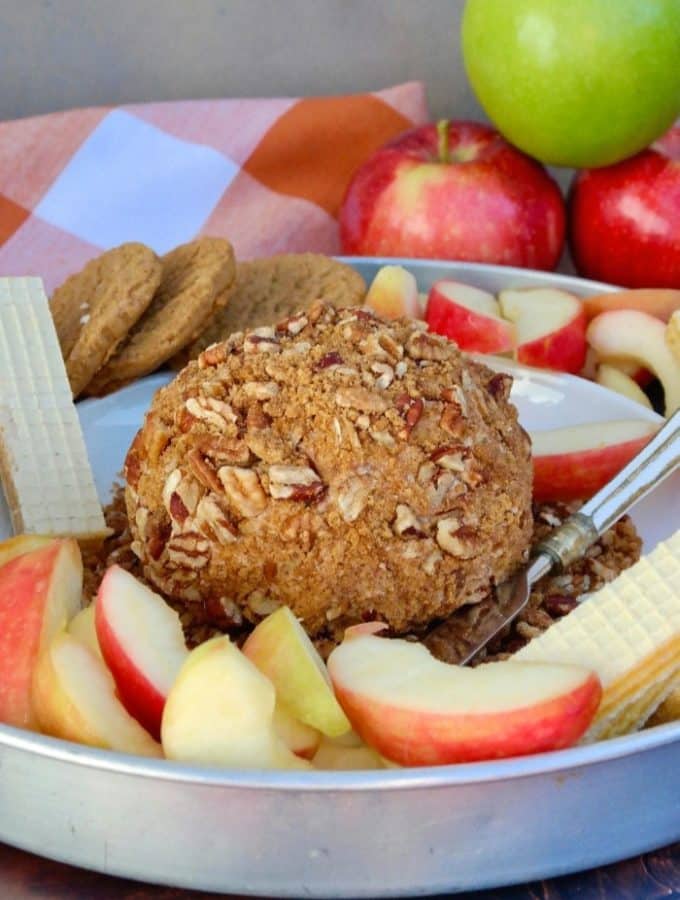 apple spice cream cheese ball on a platter with cookies and sliced apples