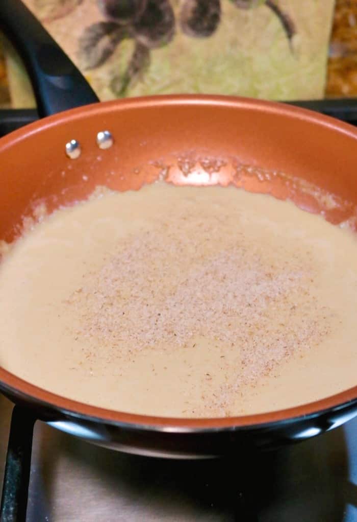 skillet pan of simmering keto gravy on the stovetop thickened with psyllium husk 