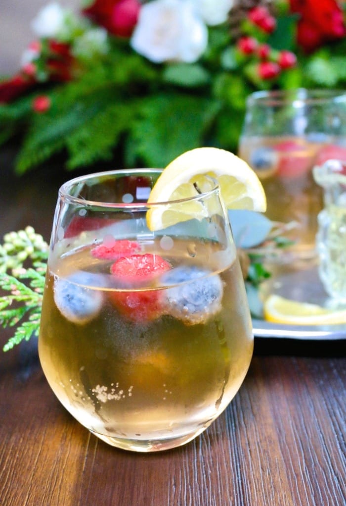 A clear glass of limoncello spritz cocktail with frozen berries