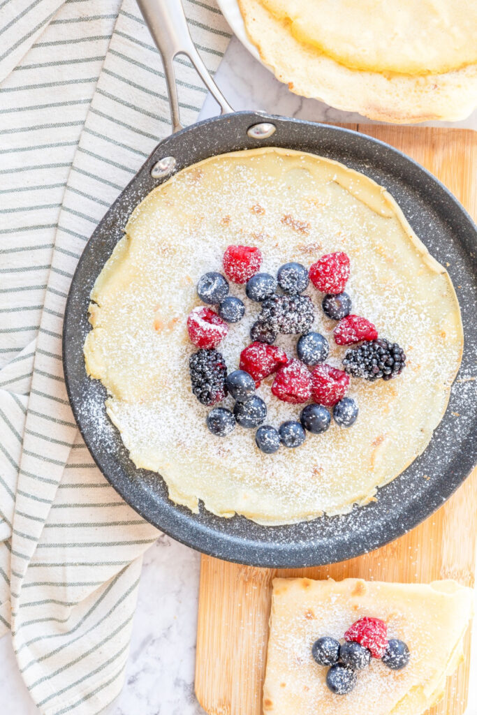 Homemade crepes with fresh berries topped with a sprinkle of confectioners sugar.