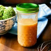 Homemade stir fry sauce in a mason jar with a whisk on the side