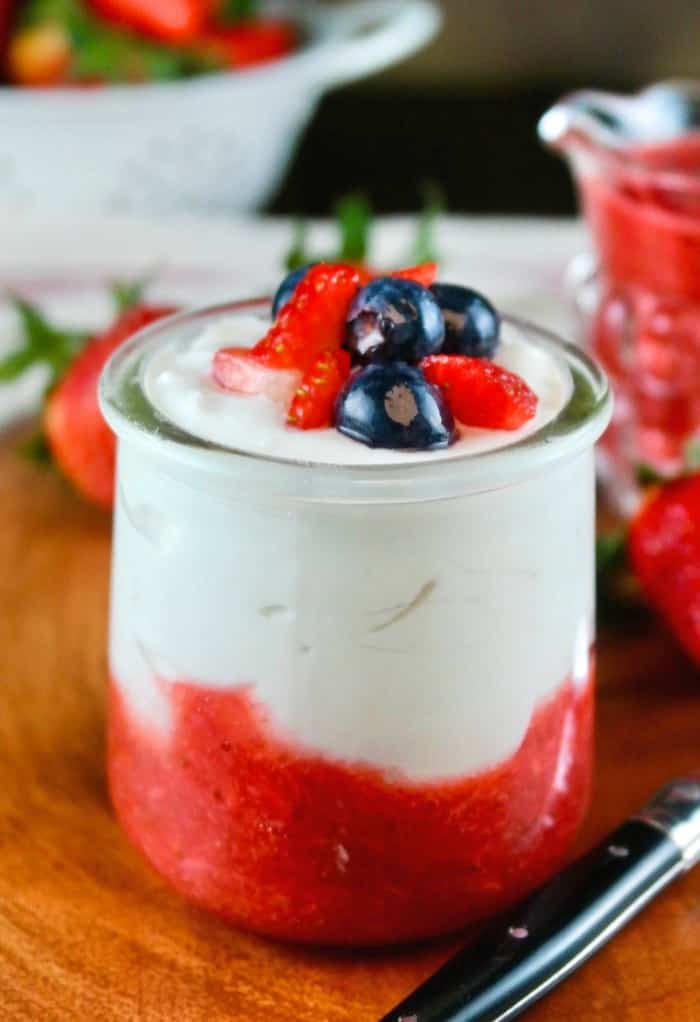 Greek yogurt in a glass jar with strawberry puree on the bottom