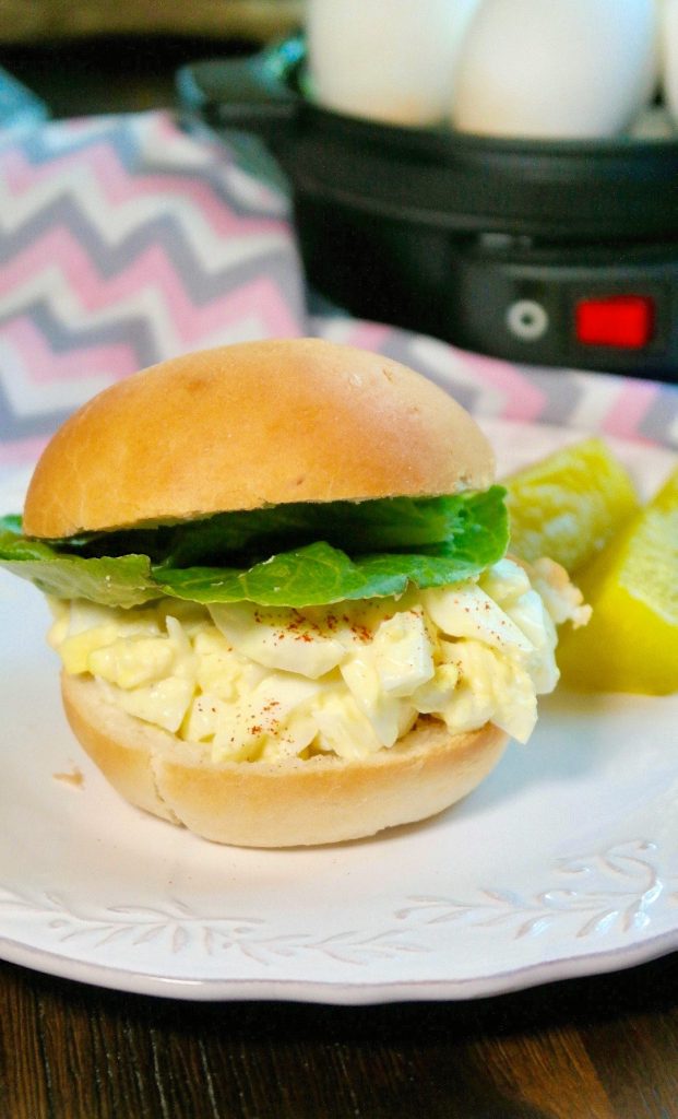 Keto egg salad topped in a roll on a white plate