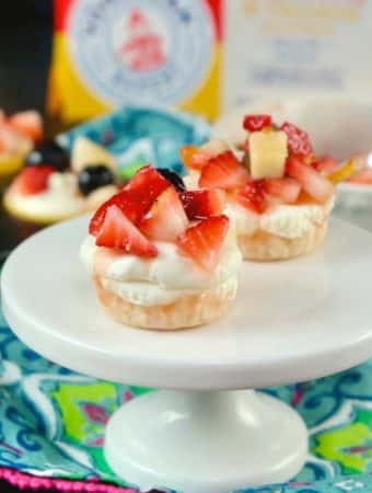 No Bake mini cheesecake recipe on a white small pedestal with floral napkin