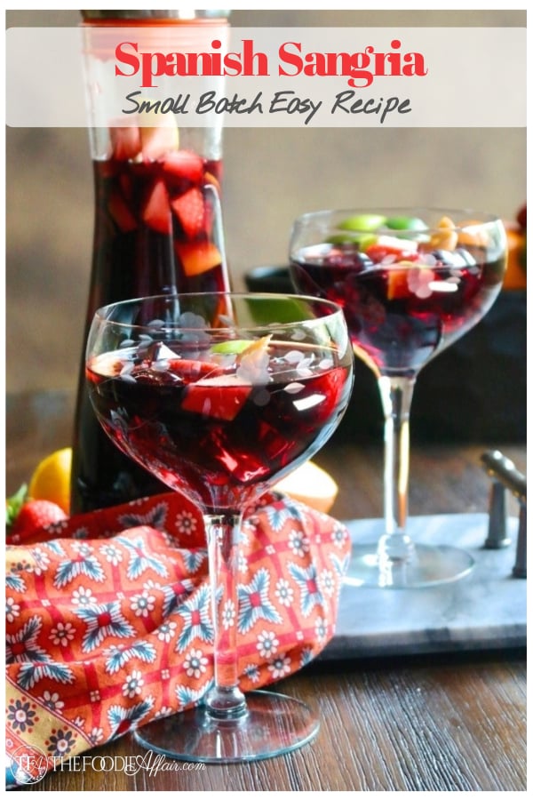 Red wine Spanish Sangria in a clear wine glass with a pitcher in the background