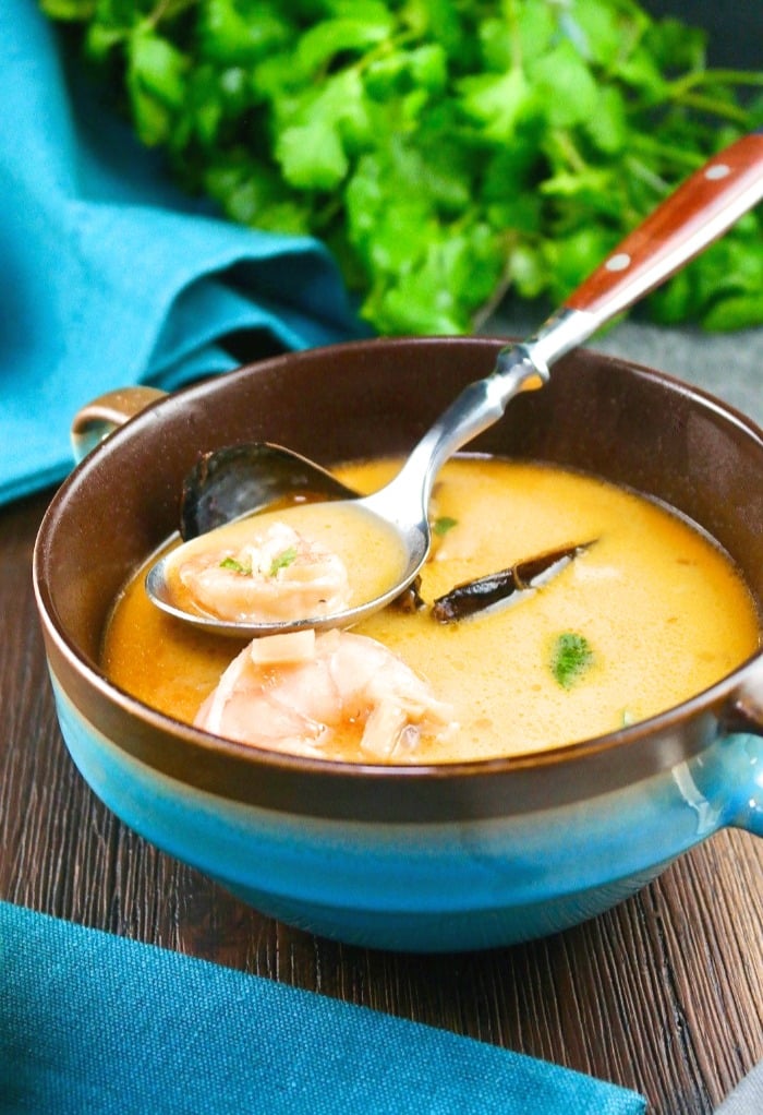 Thai coconut soup with seafood in a blue bowl