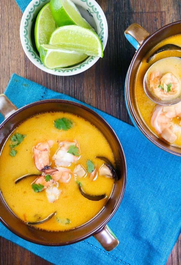 Top of two bowls of Thai coconut soup with lime wedges on the side