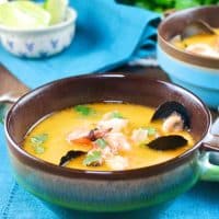 Thai coconut soup with shrimp and muscles in a blue-green soup bowl