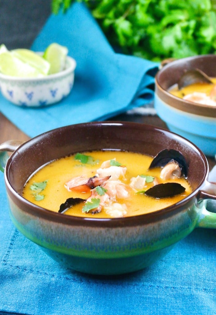 Thai coconut soup with shrimp and muscles in a blue-green soup bowl