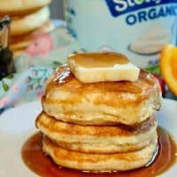 A stack of fluffy pancakes with butter and syrup