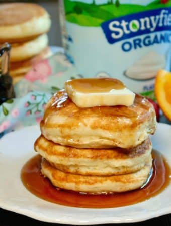 A stack of fluffy pancakes with butter and syrup