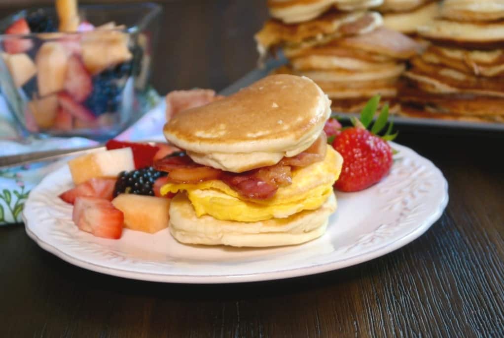 A white plate with fruit and hotcakes