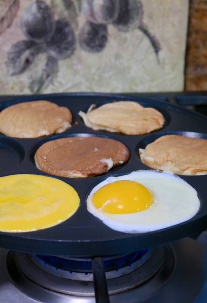 Eggs and pancakes on a black skillet