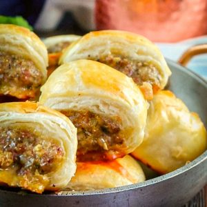 Sausage rolls on a stainless serving bowl.
