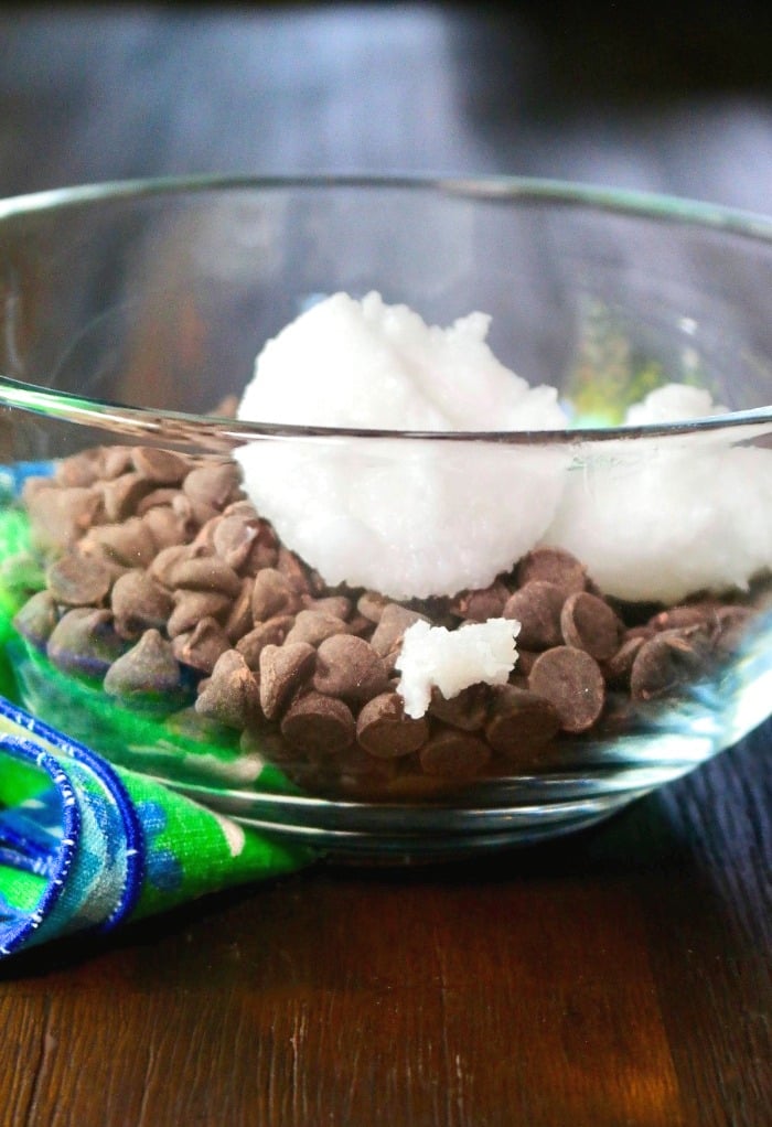 chocolate chips and coconut oil in a clear bowl 
