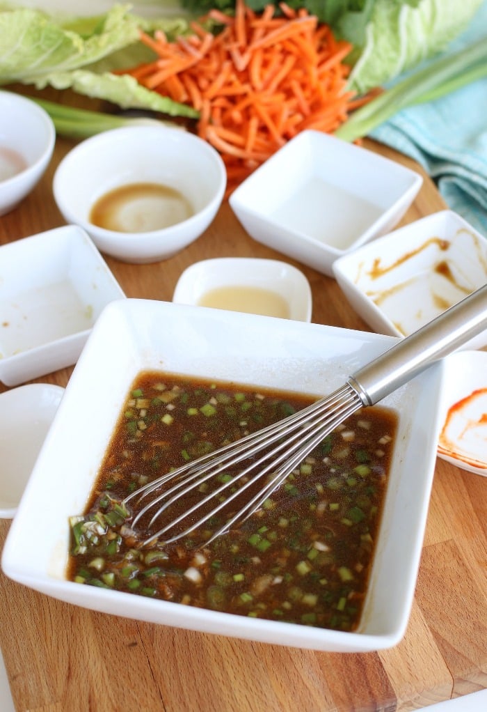 All the ingredients for an Asian dressing for salad whisked together in a bowl.