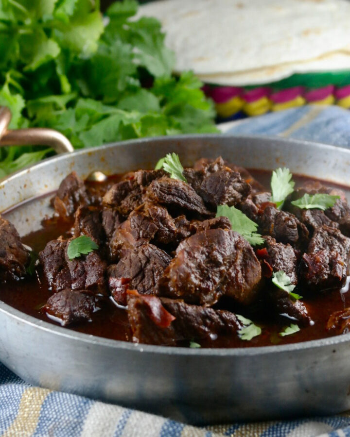 Authentic chili colorado cooked in an Instant Pot in a stainless serving dish.