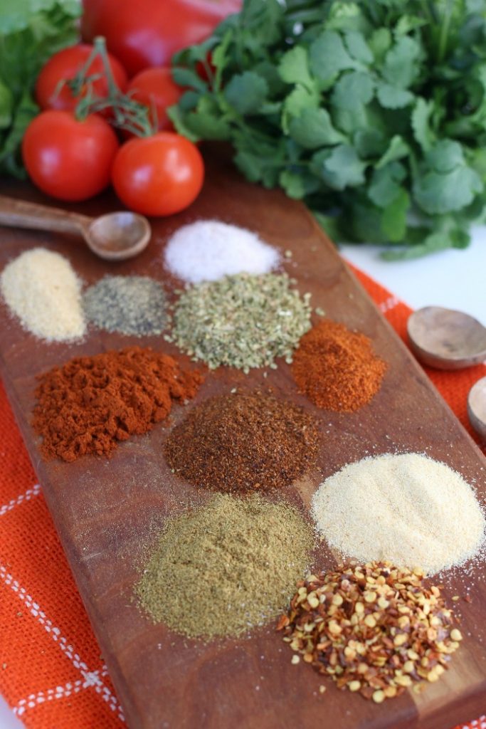 Spice ingredients for a homemade taco seasoning on a cutting board.