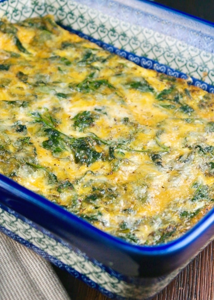 Spinach casserole with cheese and eggs in a blue Polish pottery casserole dish. 