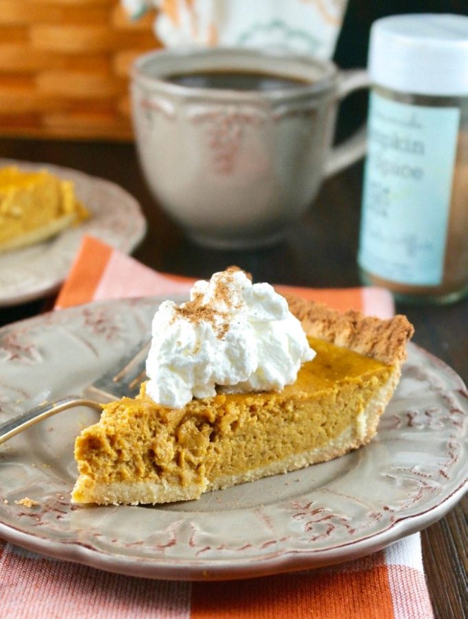 Slice of low carb pumpkin pie on a tan plate