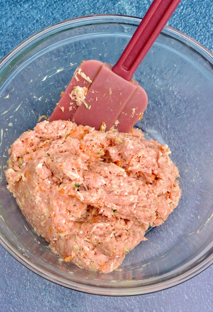 Raw ground turkey in a clear mixing bowl for meatballs.