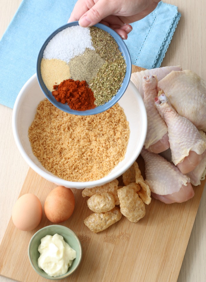 Spices being added to the breading for keto fried chicken. 