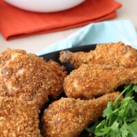 Dark platter of keto fried chicken with salad on the side.