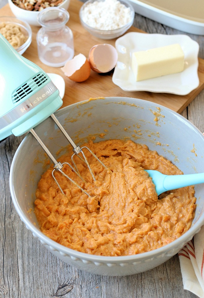 Wet ingredients being blended together with a hand mixer for my sweet potato casserole easy style recipe.