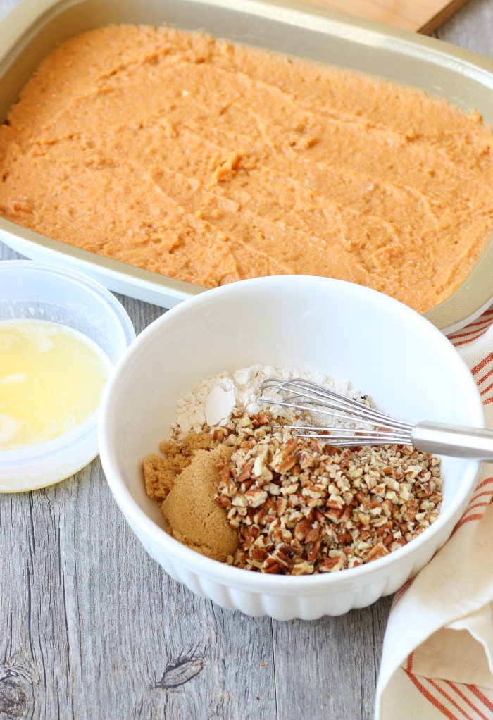 Base layer spread into a pan, sweet potato casserole with pecans topping being mixed up in a bowl.