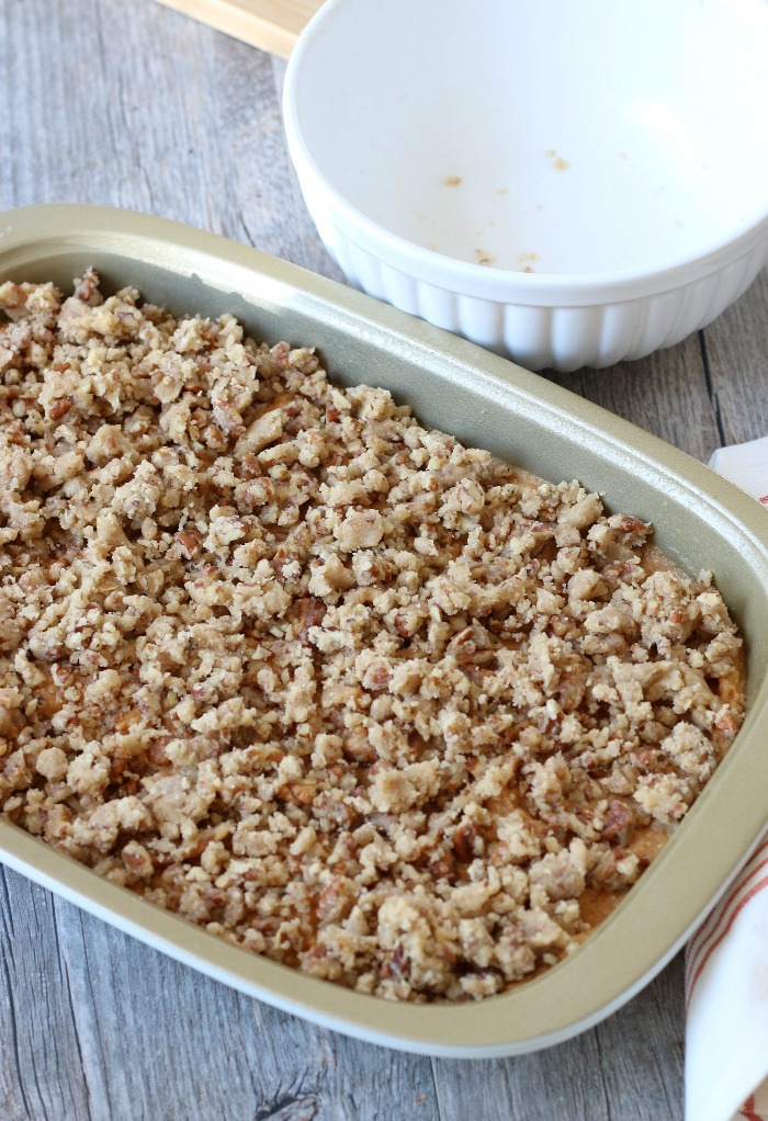 Crumbled topping layered on top of the sweet potato casserole recipe ready for the oven.